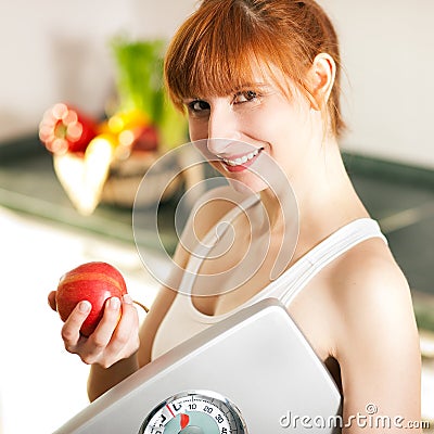 Loosing weight - woman with scale and apple Stock Photo