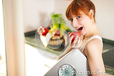 Loosing weight - woman with scale and apple Stock Photo