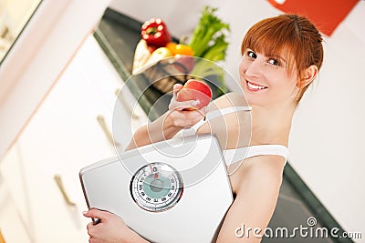 Loosing weight - woman with scale and apple Stock Photo