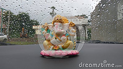 Lord Ganesha idol in car with rain drew background Editorial Stock Photo