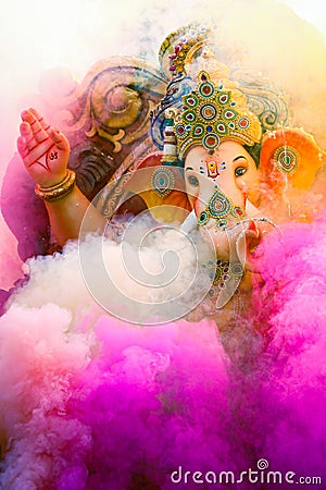 Lord Ganesha idol covered in colored smoke Editorial Stock Photo