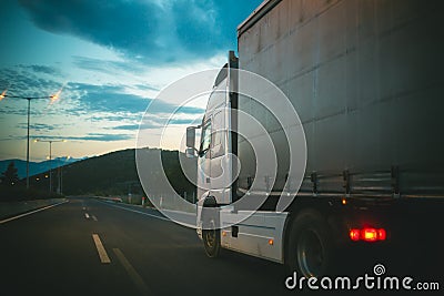 Lorry car drive on road in evening. Truck transport cargo. Transportation and shipment. Speed and delivery concept Stock Photo