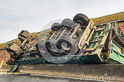 Lorry crashed, upside down at the side of a road Stock Photo