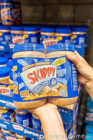 Shoppers hand holding a Twin Pack Plastic Jars of Skippy brand peanut butter Editorial Stock Photo