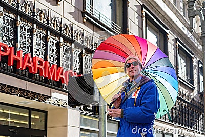 Man holding a rainbow umbrella during the Women March event Editorial Stock Photo