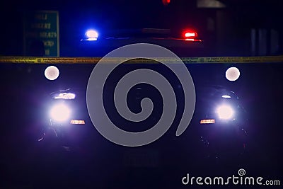 Police car seen in silhouette against search lights and roof light bar Editorial Stock Photo