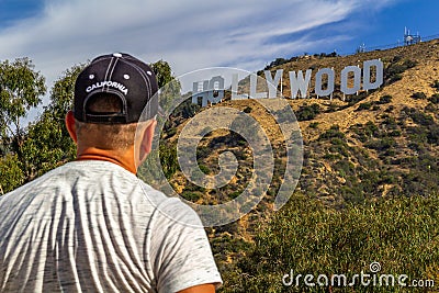 LOS ANGELES, USA - July 5, 2018, a tourist looking thoughtfully at the Hollywood sign on the Hollywood hills in California, the Editorial Stock Photo