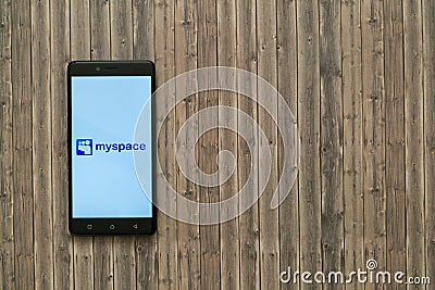 Myspace logo on smartphone screen on wooden background. Editorial Stock Photo