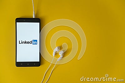 Linkedin logo on smartphone screen on yellow background Editorial Stock Photo