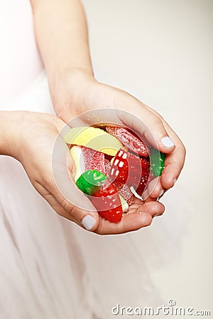A los of candies in a girl hands with plain background Stock Photo