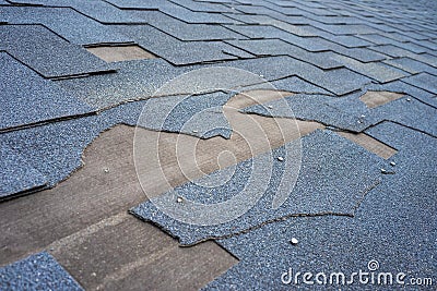 Ð¡lose up view of bitumen shingles roof damage that needs repair. Stock Photo