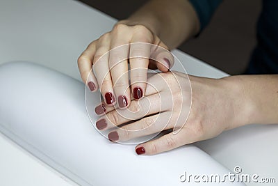 Ð¡loseup of hands of a young woman with long red manicure on nails Stock Photo