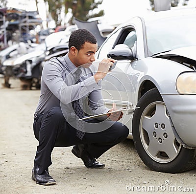 Loss Adjuster Taking Photograph Of Damage To Car Stock Photo