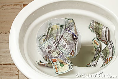 Loss of money. Bad investment or investment. Cash dollars are flushed into the toilet Stock Photo