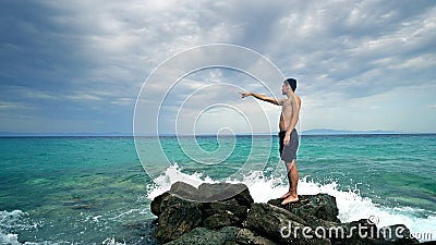 Lost alone male teen standing on sea rock Stock Photo