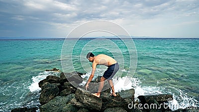 Lost alone male teen standing on sea rock Stock Photo