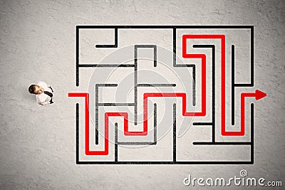 Lost businessman found the way in maze with red arrow Stock Photo