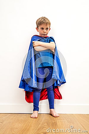 Lost little superhero child with arms folded thinking about sadness Stock Photo