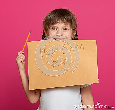 Lost tooth girl portrait, studio shoot on pink background Stock Photo