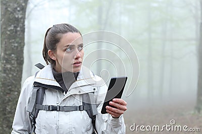 Lost trekker using phone to locate in a forest Stock Photo