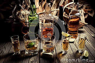 A lot of alcohol, whiskey, tequila, bourbon, brandy, rum on a wooden bar counter, vintage photo Stock Photo