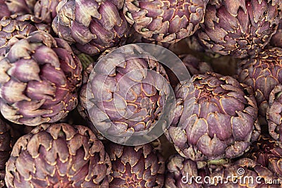 a lot of artichokes close-up. Artichokes are sold on a showcase, healthy food. Stock Photo