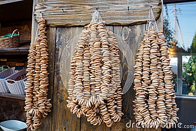 A lot of bagels on ropes hang on wooden wall in grocery Stock Photo