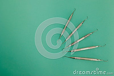 Lot of dental periodontal scalers on green background. Stock Photo