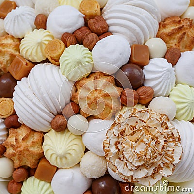 A lot of different sweets, such as: marshmallows, sweets, chocolate, biscuits and meringue in the form of carnation as a backgroun Stock Photo