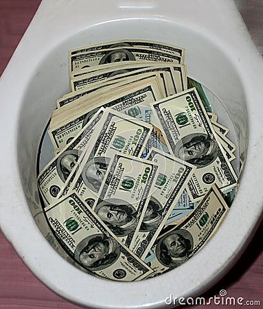 A lot of dollars in a toilet bowl. Money toilet Stock Photo