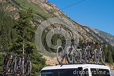 A lot mountain bicycles mounted on roof rack with mountains background. Summer vacation concept Editorial Stock Photo