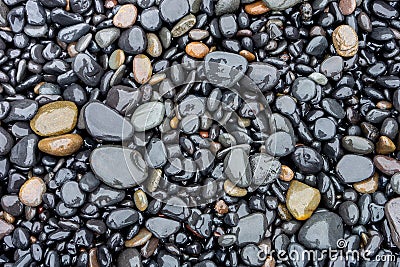 Lot of round grey wet stones on a pebble beach Stock Photo