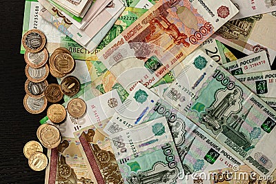 A lot of Russian metal coins and paper money lie on a black table Stock Photo