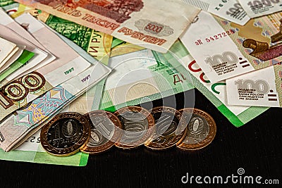 A lot of Russian metal coins and paper money lie on a black table Stock Photo