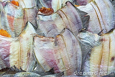 Lot of salted dried fish ocean plaice. Background of group flatfish with caviar. Close-up flat lay view of prepared and Stock Photo