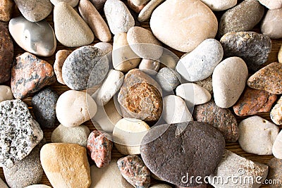 A lot of sea pebbles scattered around the table Stock Photo