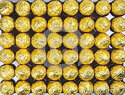 A lot of shiny golden chocolate wrapper in line on white background.. Stock Photo