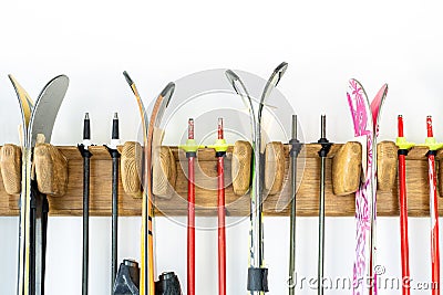 Lot of ski hanged on customized wooden wall mount at garage for seasonal storage. Extreme winter sport equipment handling at home Stock Photo