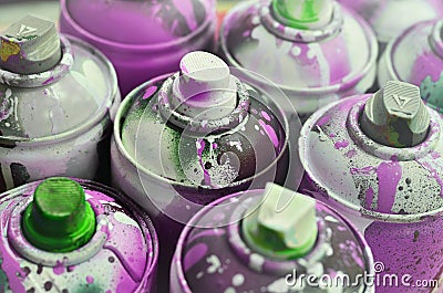 A lot of used spray cans of paint close-up. Dirty and smeared cans for drawing graffiti. The concept of a sweeping and careless d Stock Photo