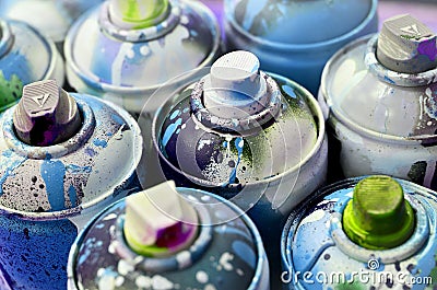 A lot of used spray cans of paint close-up. Dirty and smeared cans for drawing graffiti. The concept of a sweeping and careless Stock Photo