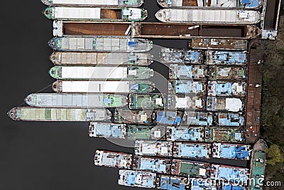 .Lots of abandoned transport barges moored side by side at the wharf. River transport industry Stock Photo