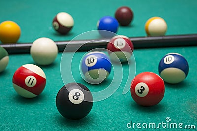 Lots of billiards and the cue on the billiard table, sports and recreation. Focused on the eight ball Stock Photo