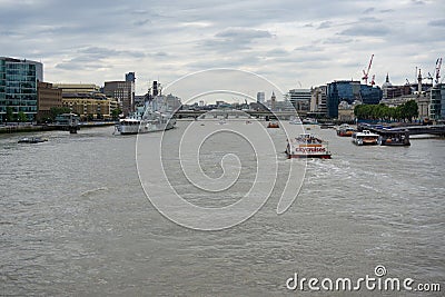 Lots of boats on River Thames London, HMS Belfast on left. Editorial Stock Photo