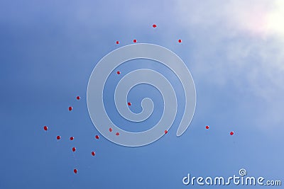 Lots of festive red balloons inflated with helium in blue sunny sky Stock Photo