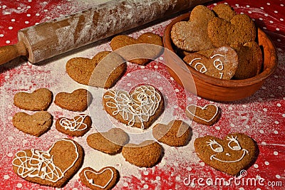 Lots of gingerbread in the shape of a heart on a flour and bowl with cookies Stock Photo