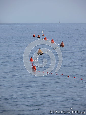 Lots of mooring buoys floating on water in marina. Small boat visible at the top of image. Calm water with small waves Stock Photo