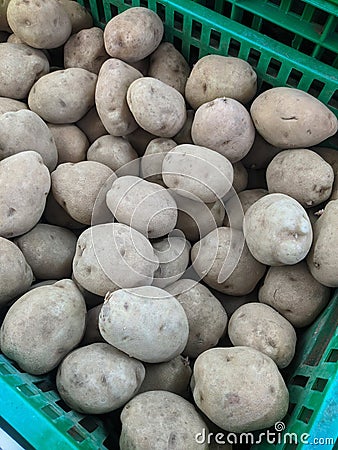 lots of potatoes in the green basket Stock Photo