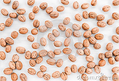 Lots of walnuts scattered on white wooden background Stock Photo