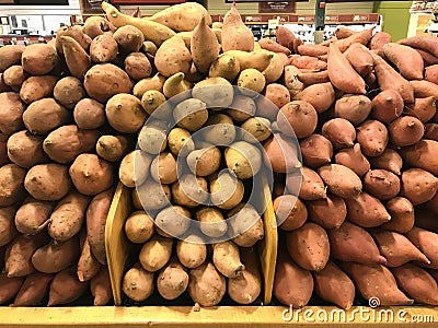 Yams and sweet potatoes stacked up at the market Stock Photo