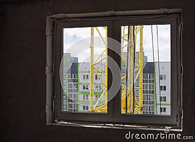 Loud construction site noise immission in opened one frame of white pvc window, view through Stock Photo